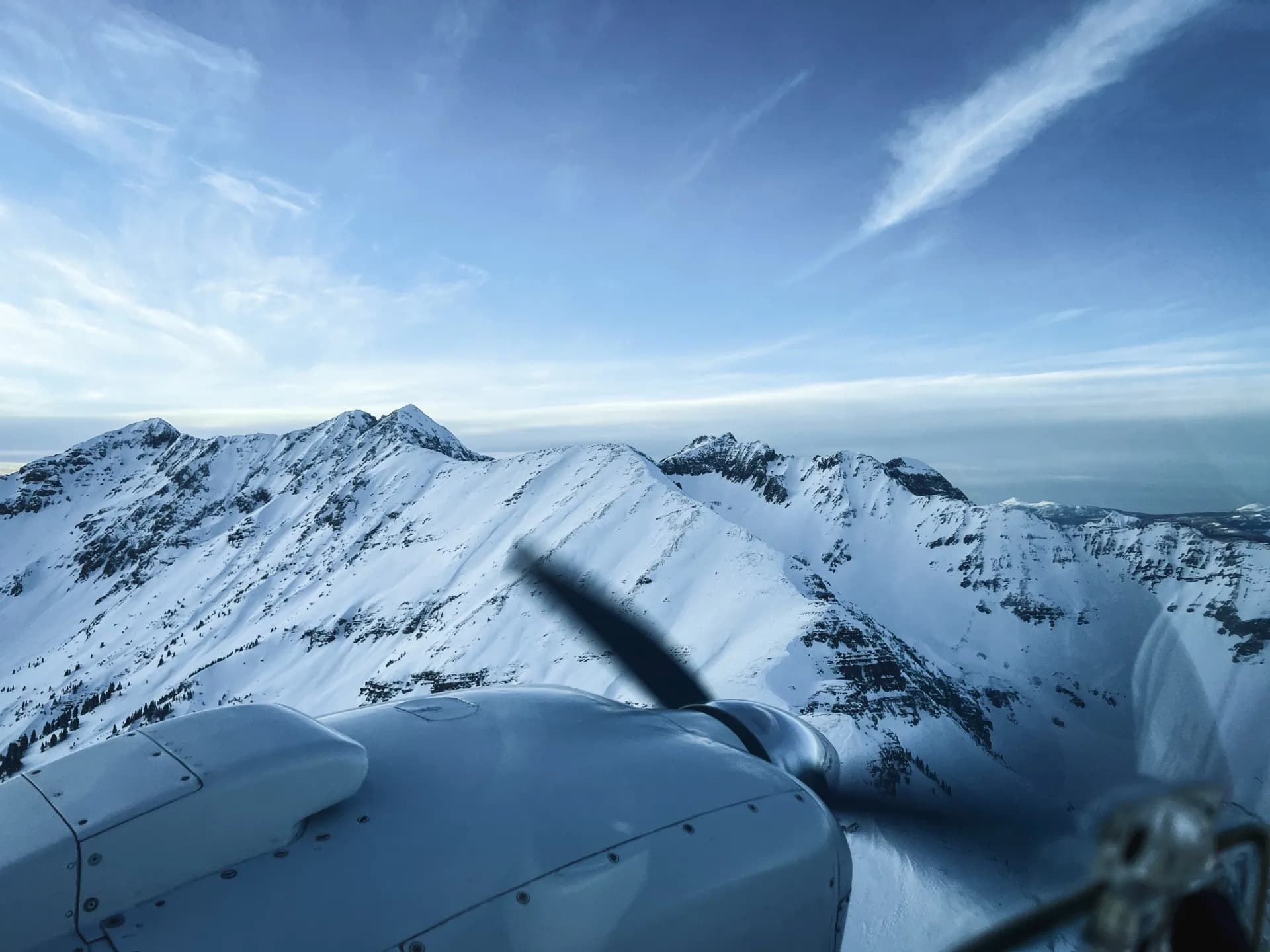 Aircraft propeller over snow-capped mountain peaks
